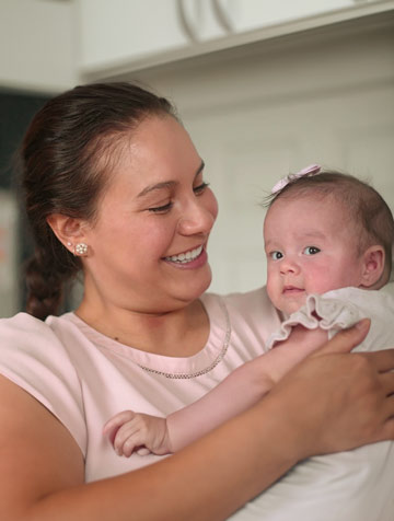 smiling mother holding her baby